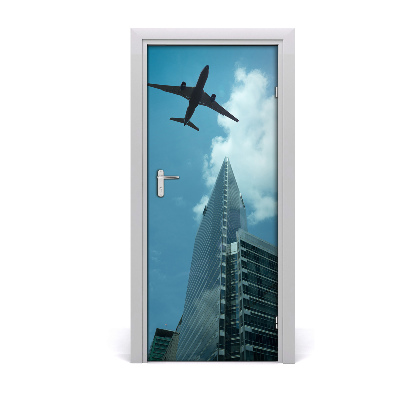 Pegatina para puerta Avión sobrevolando la ciudad