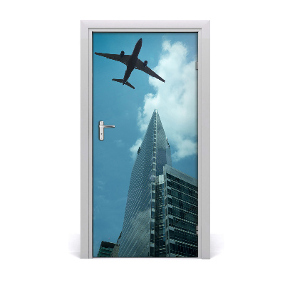 Pegatina para puerta Avión sobrevolando la ciudad