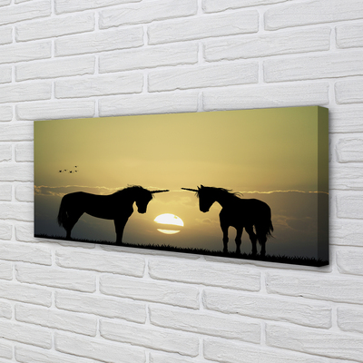 Cuadros sobre lienzo Unicornios puesta de sol sobre el terreno