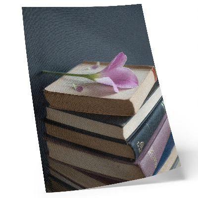 Póster con colores saturados Una pila de libros con una delicada flor encima.