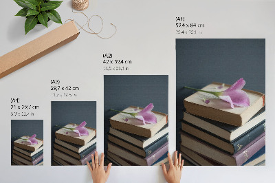 Póster con colores saturados Una pila de libros con una delicada flor encima.