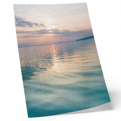 Póster Superficie del agua en calma, colores cálidos del cielo, puente