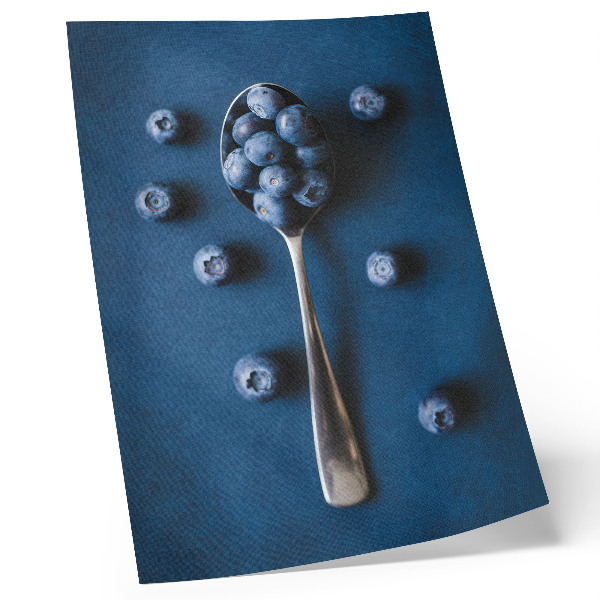 Póster con colores saturados Arándanos en una cuchara sobre fondo azul, elegancia