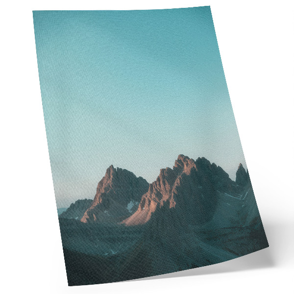 Póster Impresionantes montañas bajo un cielo azul brillante.