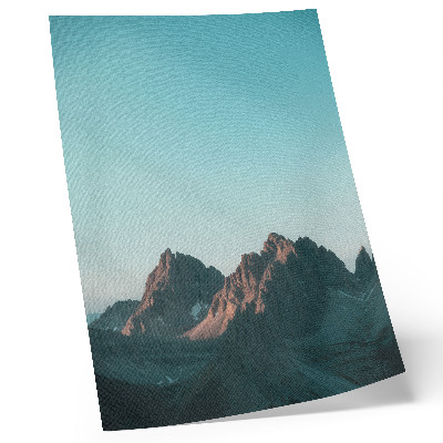 Póster Impresionantes montañas bajo un cielo azul brillante.