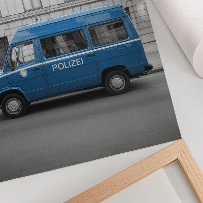 Póster Un coche de policía azul con un edificio al fondo.