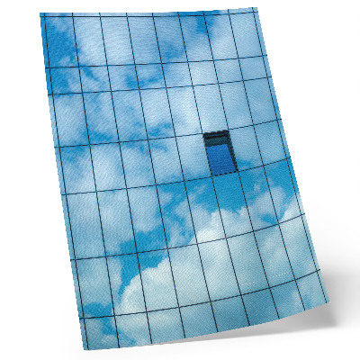 Póster Una fachada de cristal que refleja el cielo y las nubes.