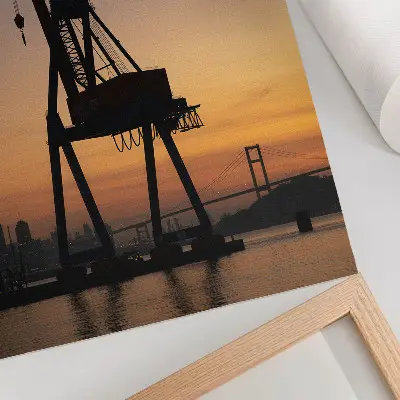 Póster de puente con silueta de grúa industrial al atardecer con colores saturados