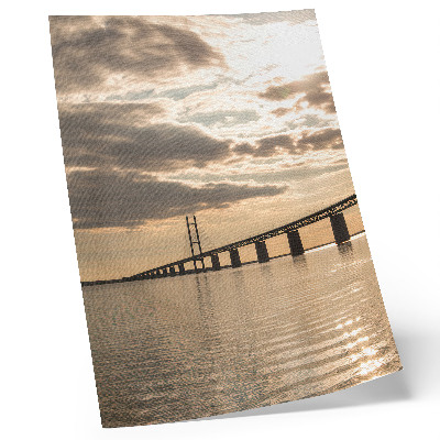 Póster Un puente sobre el agua a la luz del sol poniente.