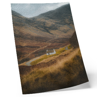 Póster Un paisaje montañoso con una cabaña solitaria en medio de la naturaleza.