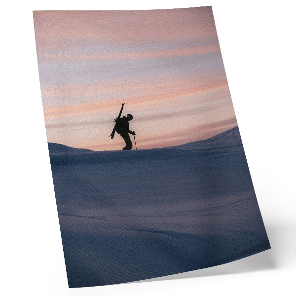 Lámina artística de alta calidad Esquiador contra un cielo rosado en un paisaje invernal.
