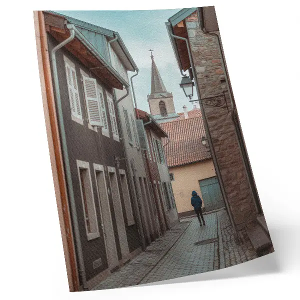 Póster calle estrecha con edificios de viviendas y torre de abrigo azul
