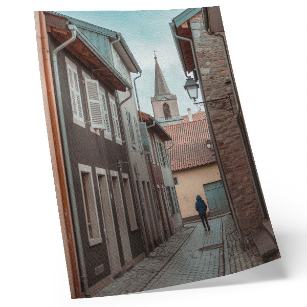 Póster Calle estrecha, edificios de viviendas, torre, abrigo azul
