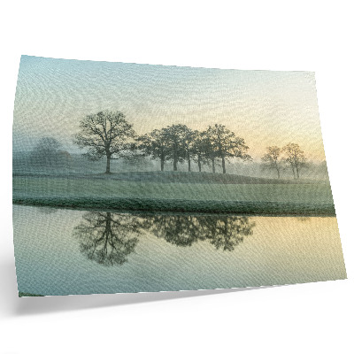 Lámina para cuadro Superficie del agua en calma, reflejo de los árboles, niebla suave.