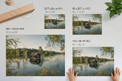 Póster Cabaña junto al lago con el reflejo del agua del bosque como telón de fondo, en un ambiente de paz.
