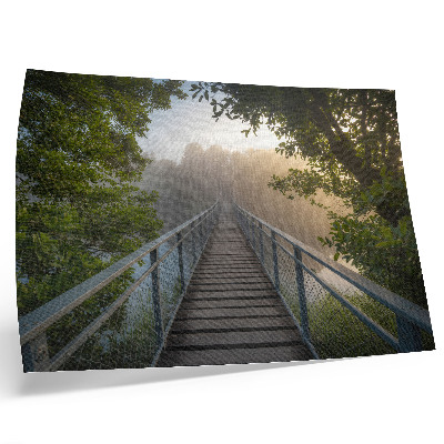 Póster Un puente entre la niebla sobre un río en un entorno verde.