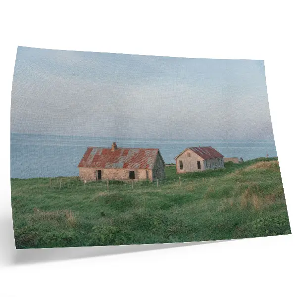 Póster con paisaje de edificios rústicos prados verdes y mar