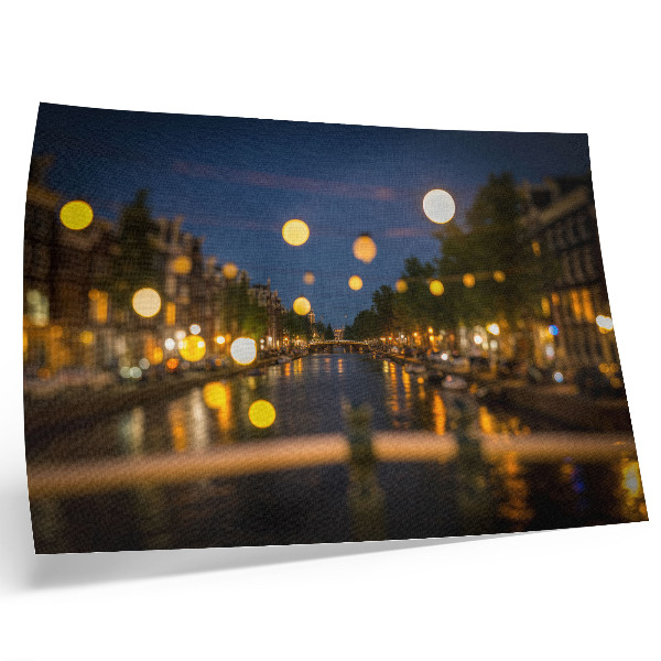 Póster Una ciudad encantadora de noche, con las luces reflejadas en el agua.