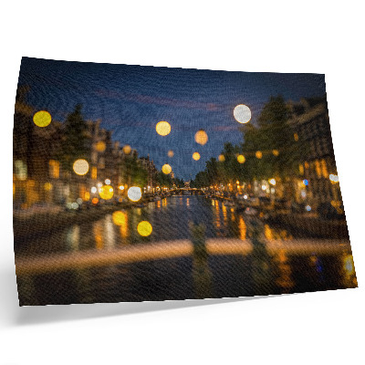 Póster Una ciudad encantadora de noche, con las luces reflejadas en el agua.