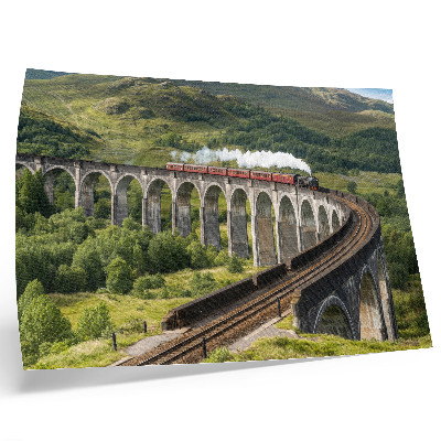 Lámina para cuadro Un viaducto con un tren entre verdes colinas.