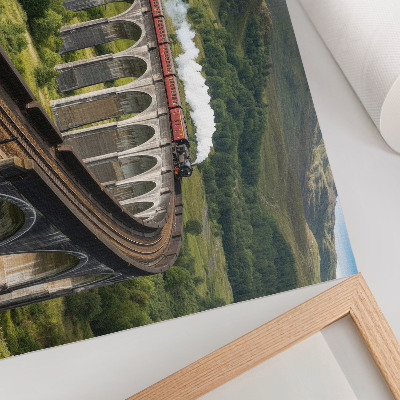Lámina para cuadro Un viaducto con un tren entre verdes colinas.