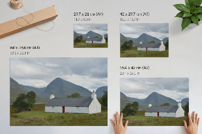 Lámina para cuadro Una casita blanca entre montañas y vegetación.