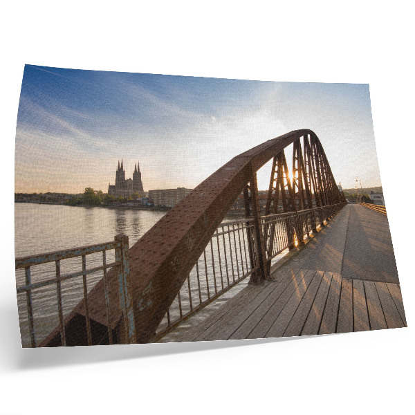 Póster puente metálico sobre el río frente a la catedral al atardecer