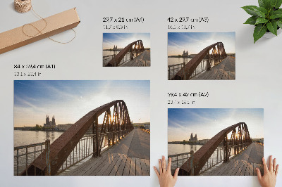Póster puente metálico sobre el río frente a la catedral al atardecer