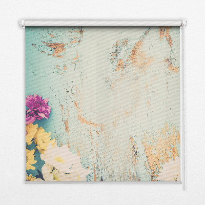 Estor enrollable de tela con flores sobre un fondo azul