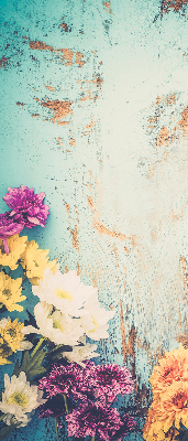 Estor enrollable de tela con flores sobre un fondo azul