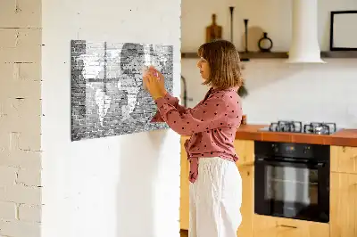 Pizarra magnética de pared con diseño de mapa del mundo sobre ladrillos y rotulador