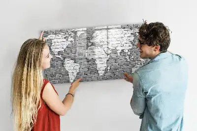 Pizarra magnética de pared con diseño de mapa del mundo sobre ladrillos y rotulador