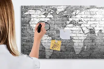 Pizarra magnética de pared con diseño de mapa del mundo sobre ladrillos y rotulador