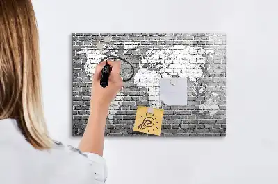 Pizarra magnética de pared con diseño de mapa del mundo sobre ladrillos y rotulador