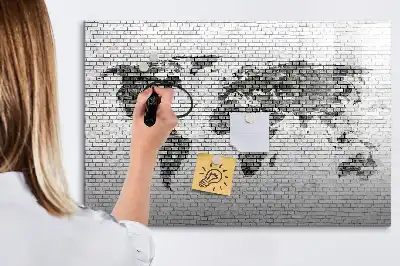 Mapa del mundo sobre pared de ladrillo con pizarra magnética y rotulador