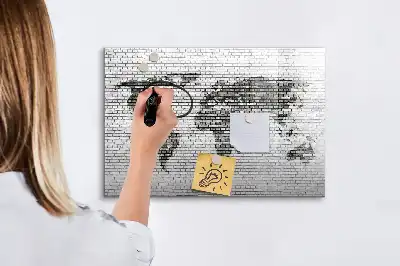 Mapa del mundo sobre pared de ladrillo con pizarra magnética y rotulador