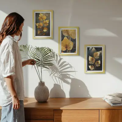 Juego de 3 cuadros decorativos con diseño de hojas en tonos amarillos sobre fondo oscuro