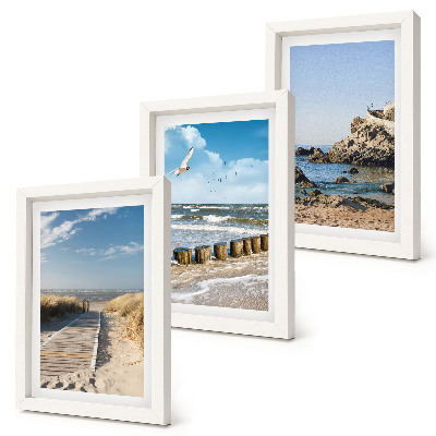 Tríptico enmarcado Playa con sendero de madera, mar y acantilados costeros.