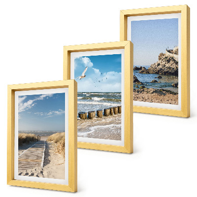 Tríptico enmarcado Playa con sendero de madera, mar y acantilados costeros.