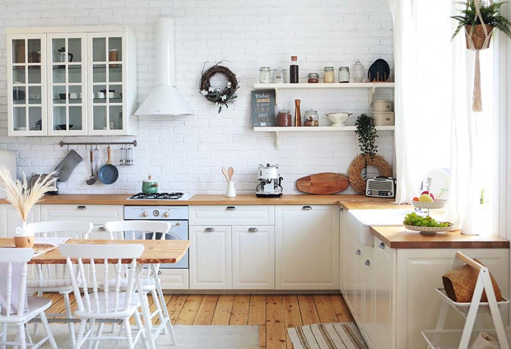 una cocina blanca con una encimera de madera