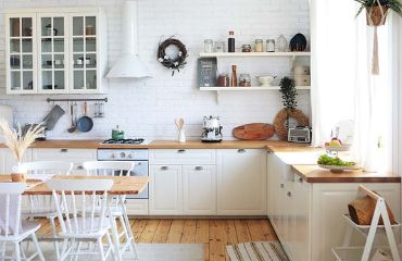 Diseño elegante de la cocina, es decir, una cocina blanca con una encimera de madera